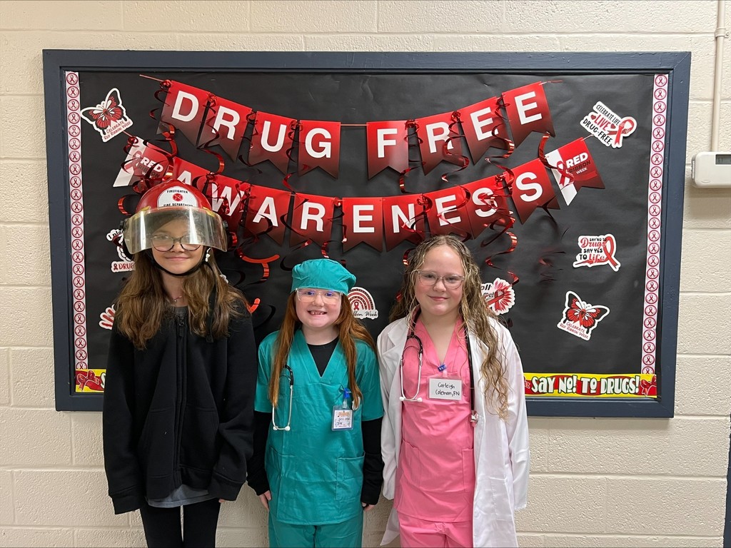 wces students participating in red ribbon week holding up prizes and dressed on special red ribbon days