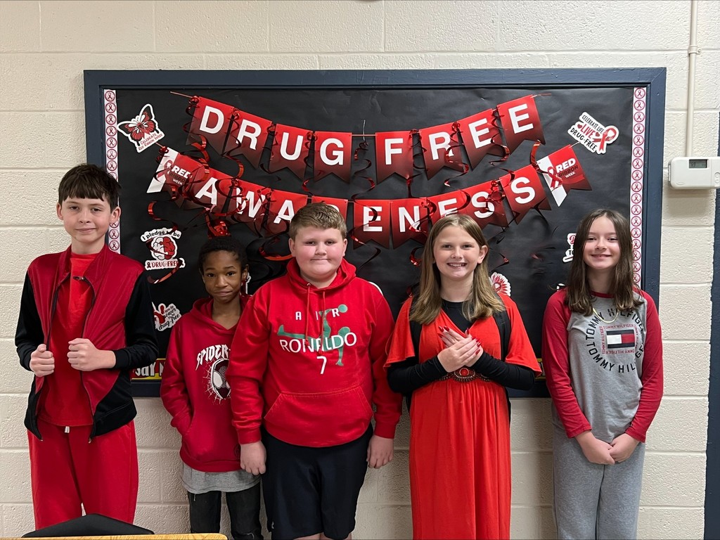 wces students participating in red ribbon week holding up prizes and dressed on special red ribbon days