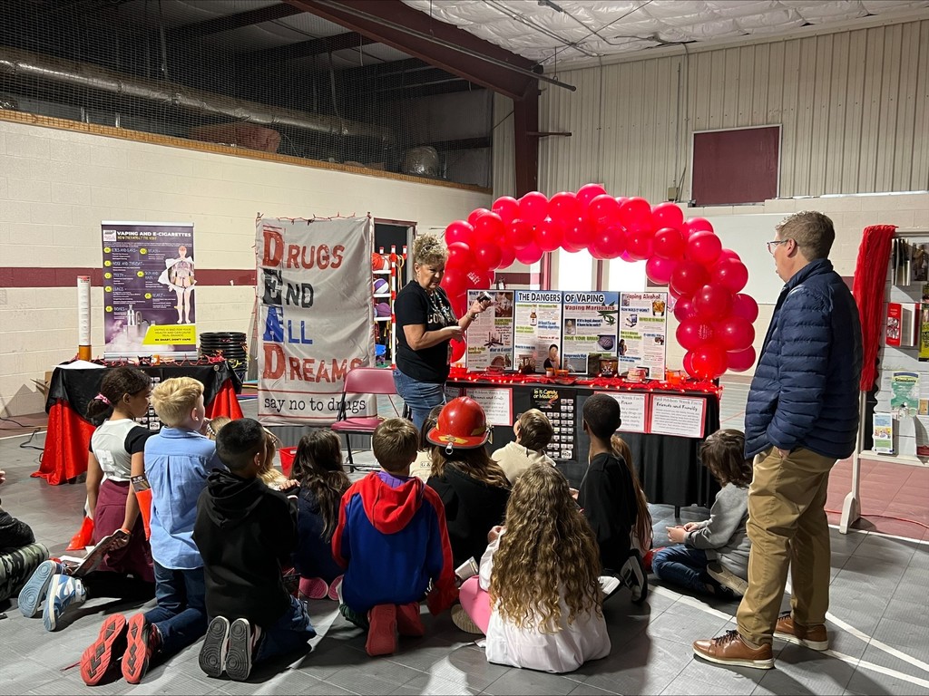 wces students participating in red ribbon week holding up prizes and dressed on special red ribbon days