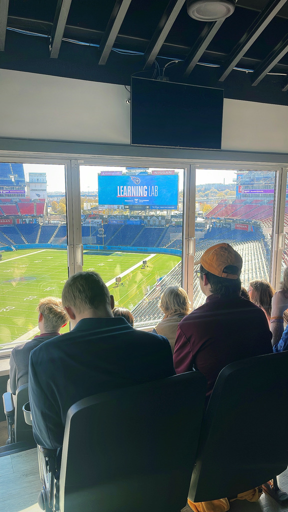 West Carroll FBLA students seated in a suite overlooking Nissan Stadium, while the jumbotron displays the Learning Lab logo