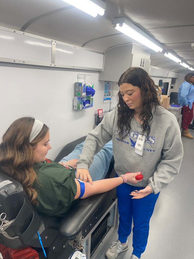 Nurse preparing a student to take her blood donatino