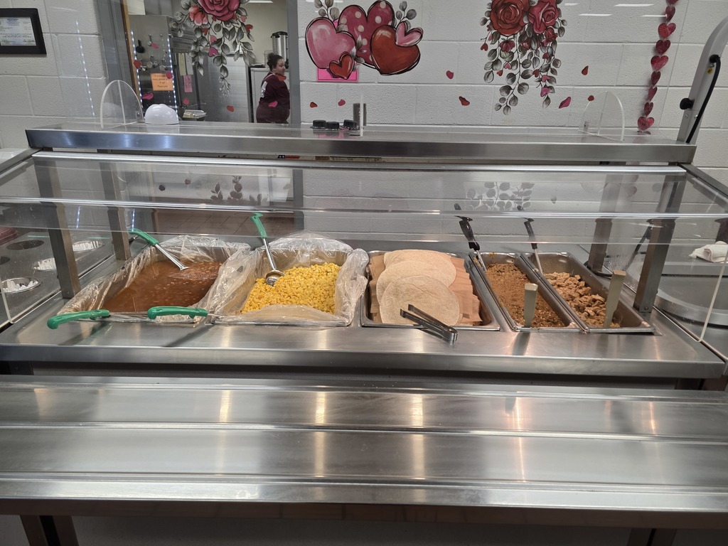 Cafeteria lunch featuring taco bar including various protein options, beans, corn and tortilla