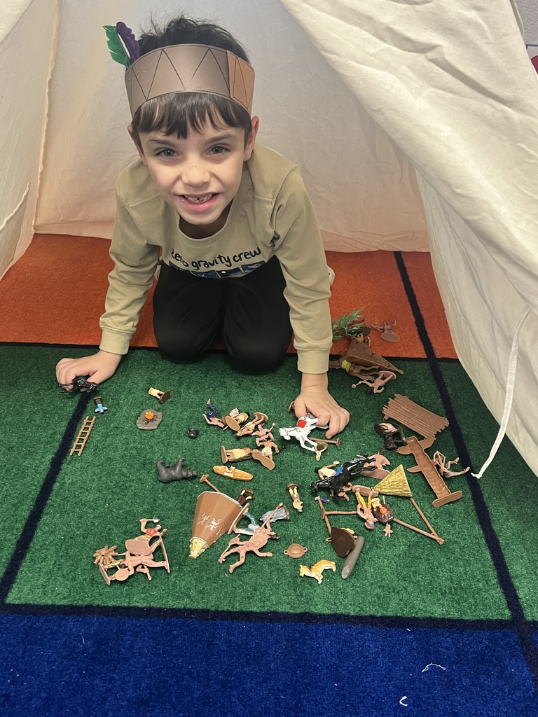kindergarten students dressed as native americans in a tipi celebrating native american cultures