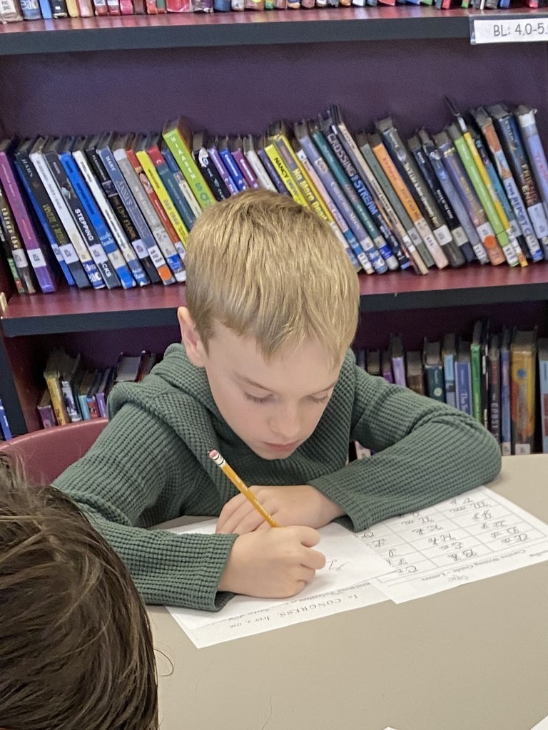 wces students practicing names like john hancock in the library