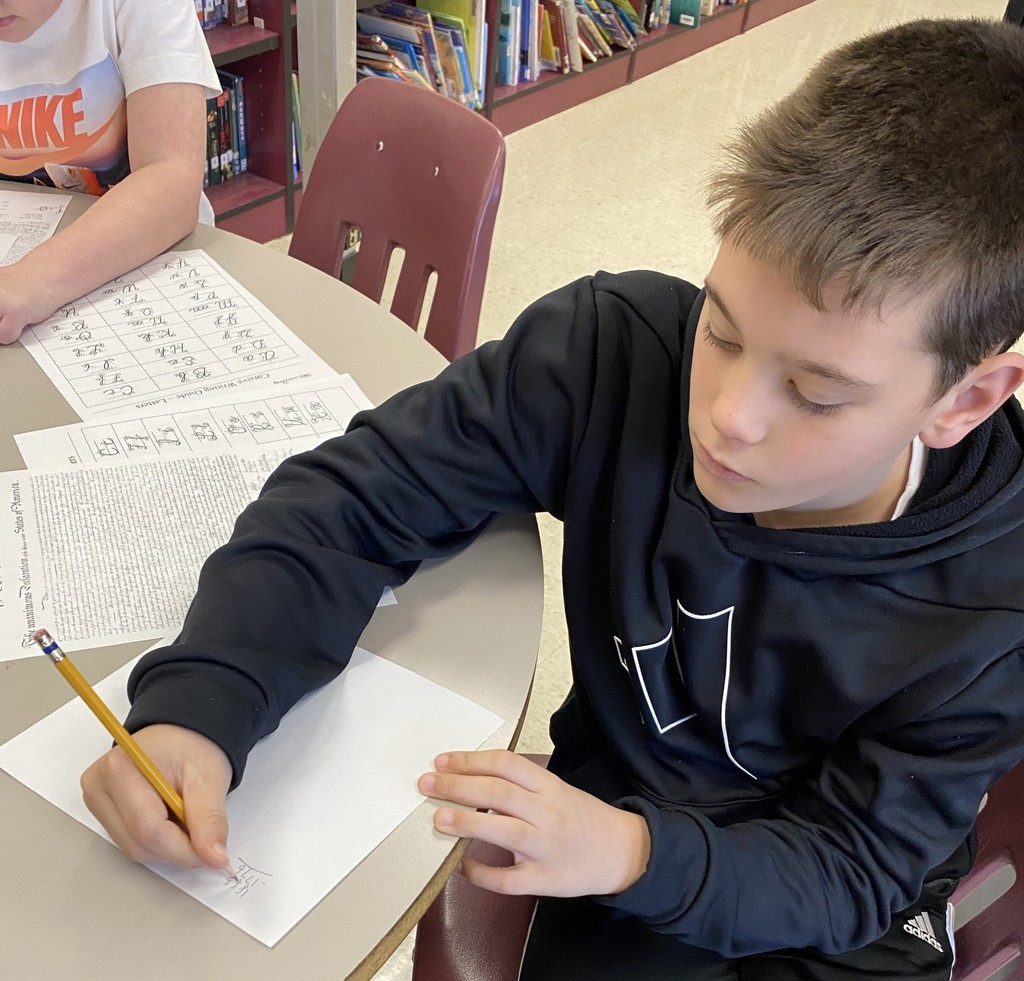 wces students practicing names like john hancock in the library