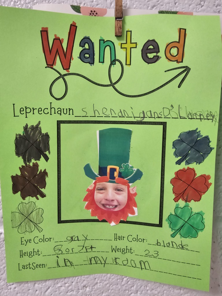 wcp student with leprechaun hat and beard for their own leprechaun writing page describing with adjectives and physical traits like eye color, hair, height, student writing illegible