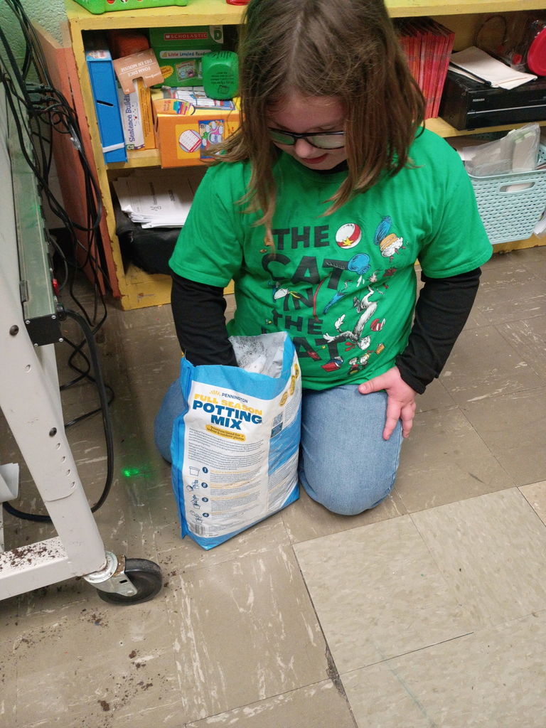 west carroll students holding  soil and seeds as they begin learning about plants