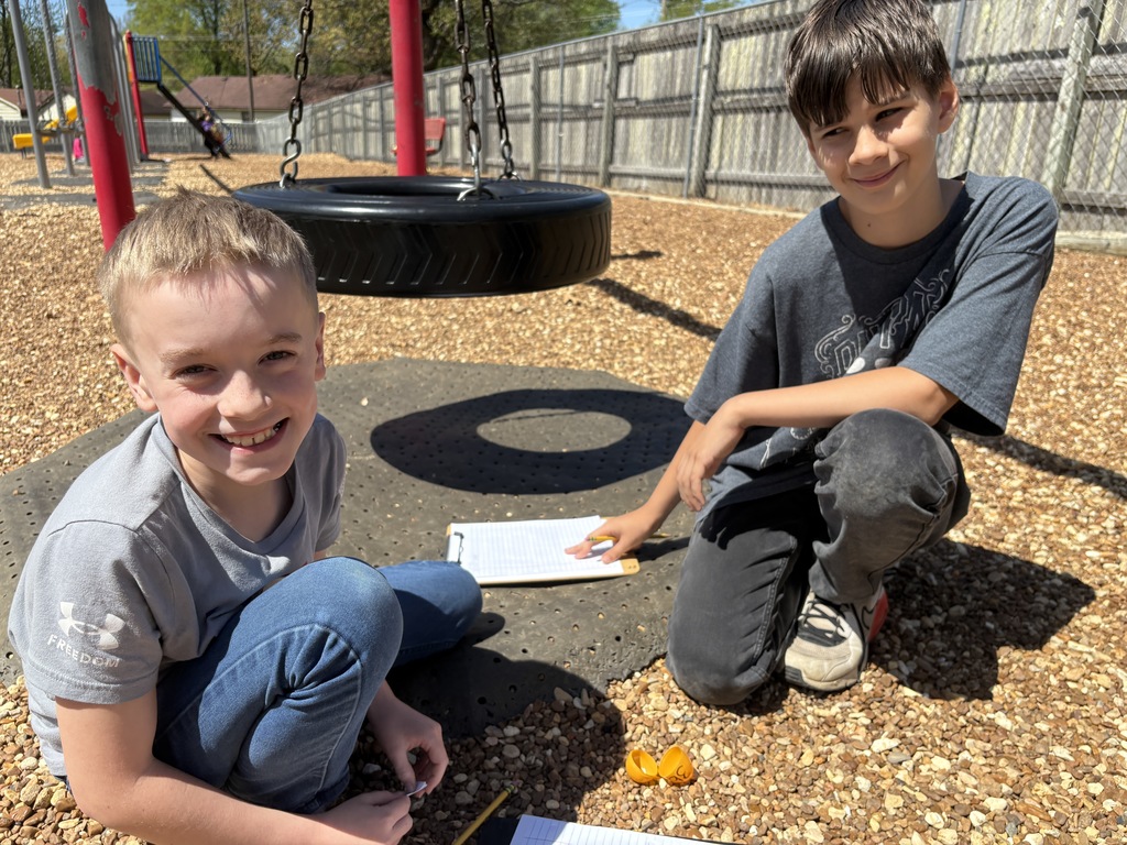west carroll elementary school students hunted for eggs for test prep before easter; students are on the school playground smiling as they find eggs and write down assessment practice questins