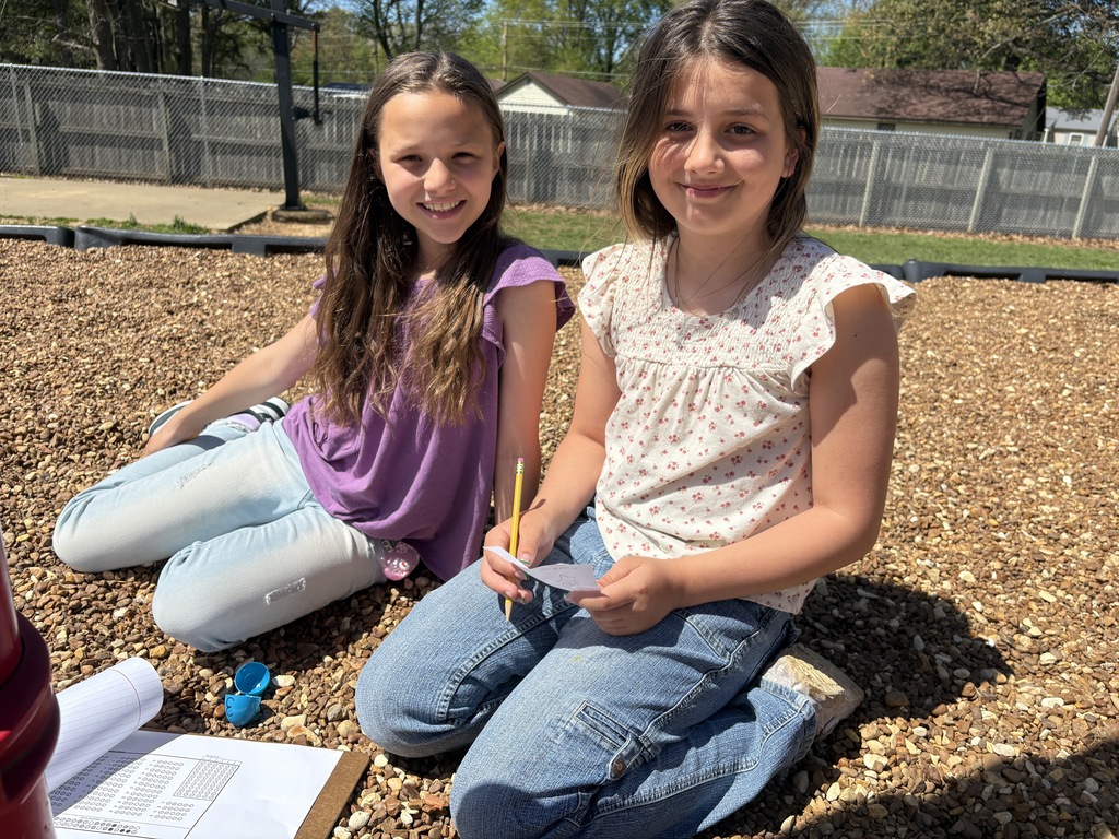 west carroll elementary school students hunted for eggs for test prep before easter; students are on the school playground smiling as they find eggs and write down assessment practice questins