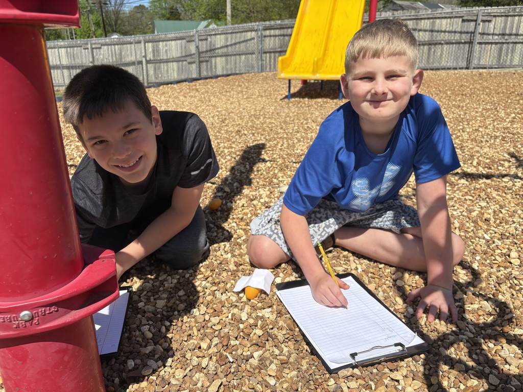 west carroll elementary school students hunted for eggs for test prep before easter; students are on the school playground smiling as they find eggs and write down assessment practice questins