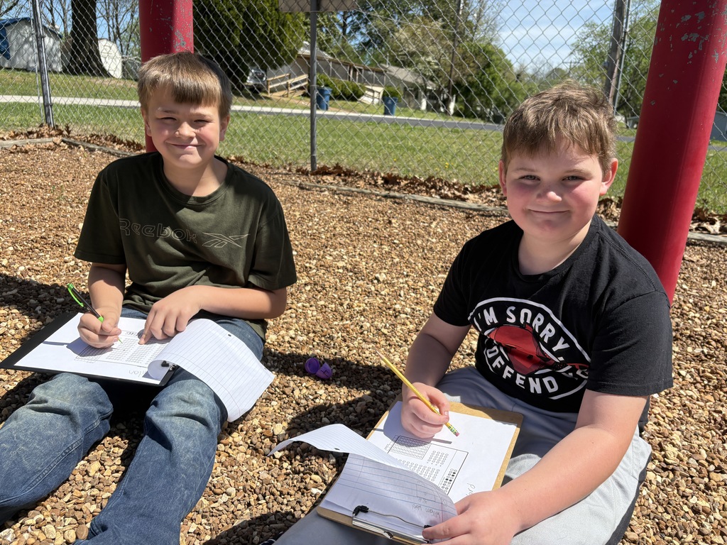 west carroll elementary school students hunted for eggs for test prep before easter; students are on the school playground smiling as they find eggs and write down assessment practice questins