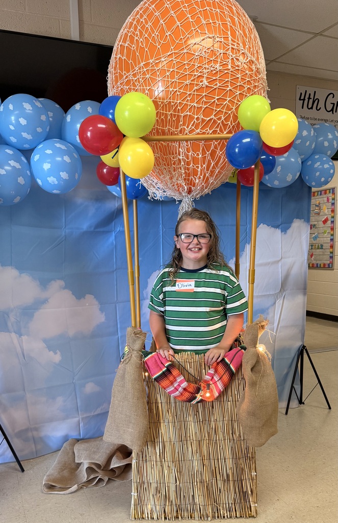 second grader posing with balloon photo area