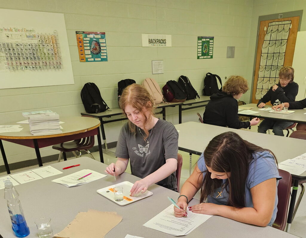 Students completing a surface tension experiment in biology