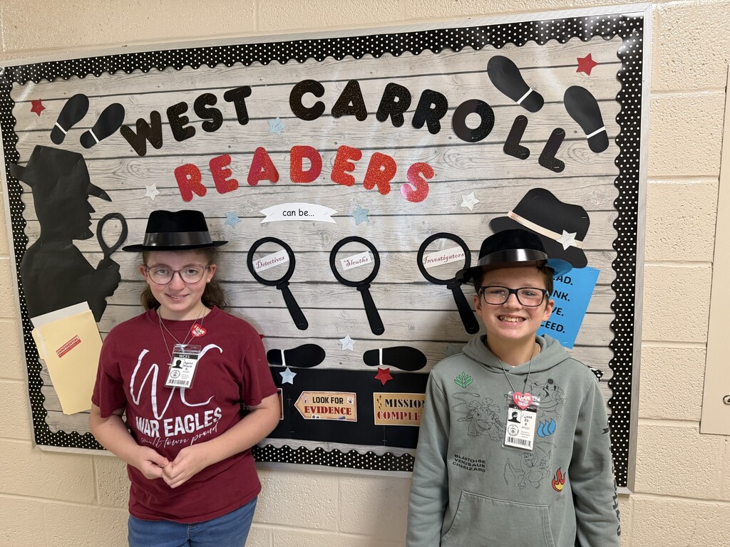 two students standing in front of bulleting board that reads west carroll readers