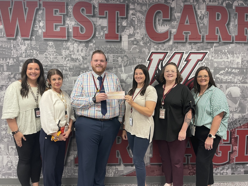 Principal Adam Douglas pictured with various staff members with recent grant check for teacher morale 