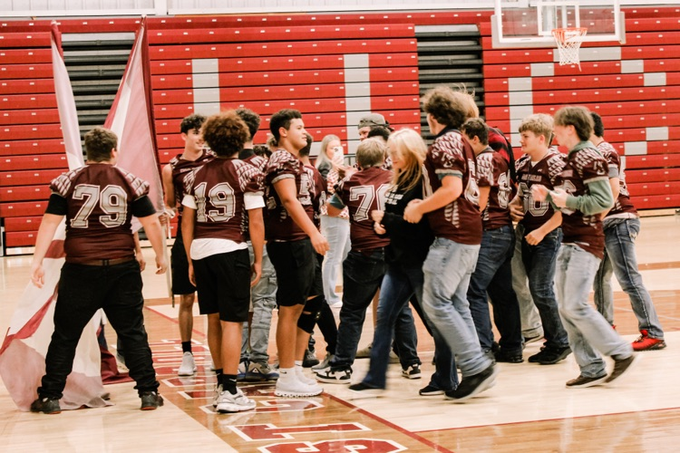 Photos from pep rally featuring cheering student body in the high school gym. 