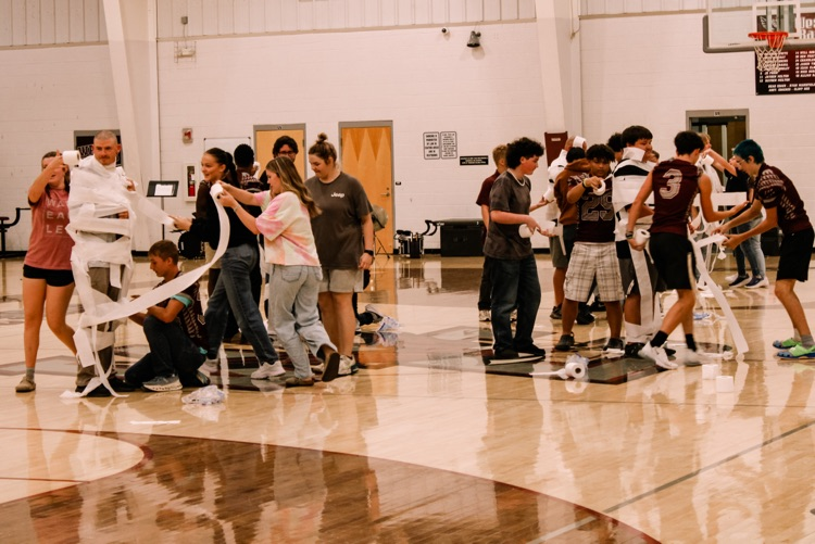 Photos from pep rally featuring cheering student body in the high school gym. 