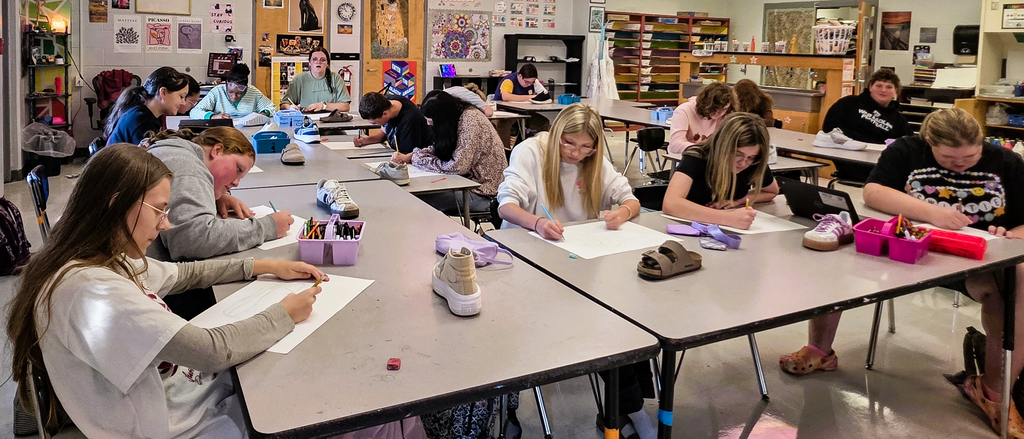 Art students working on line drawings of shoes