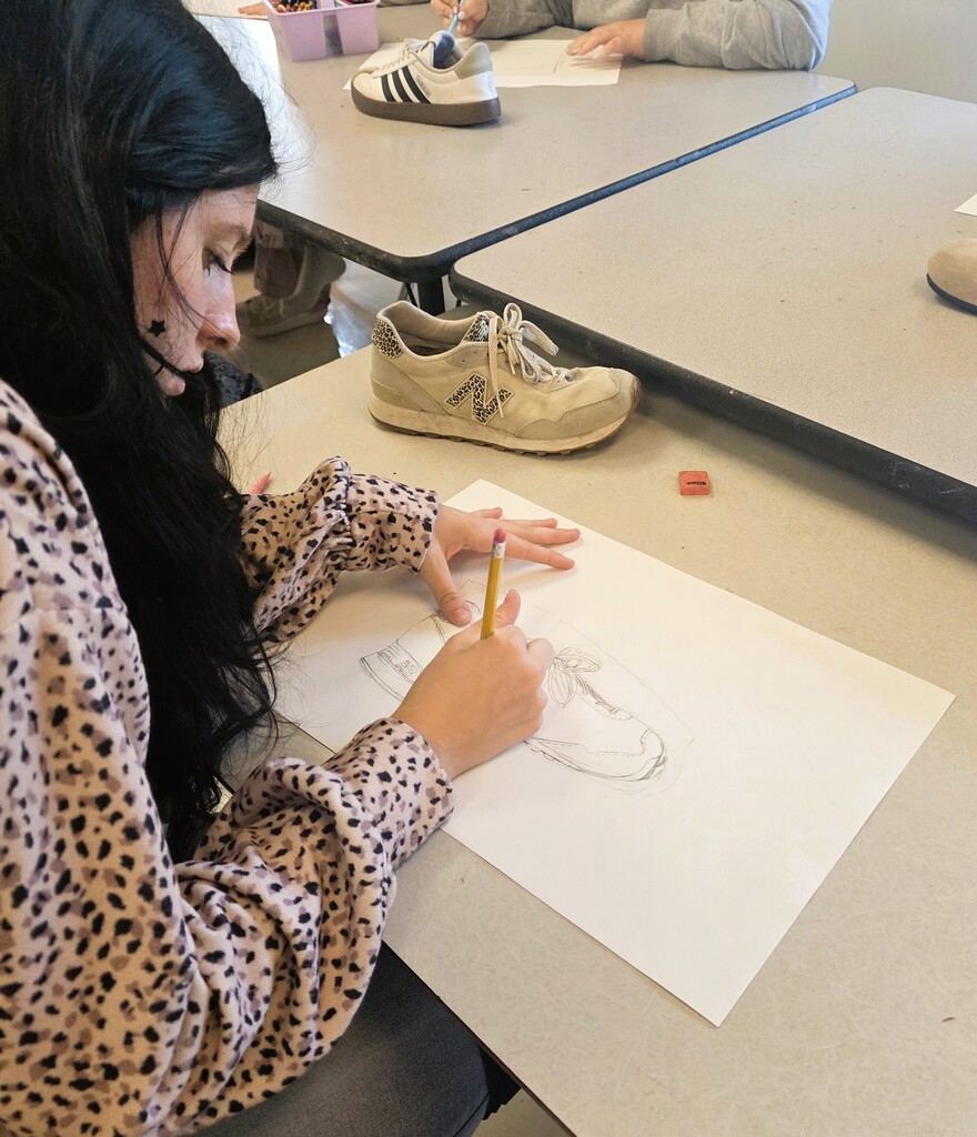 Art students working on line drawings of shoes