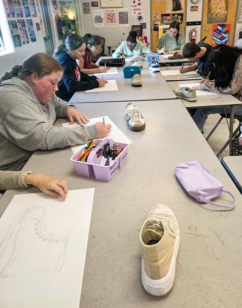 Art students working on line drawings of shoes