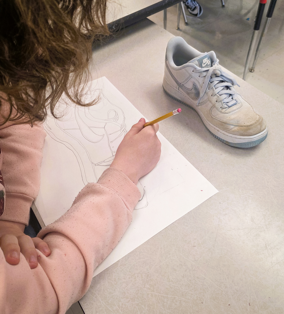 Art students working on line drawings of shoes