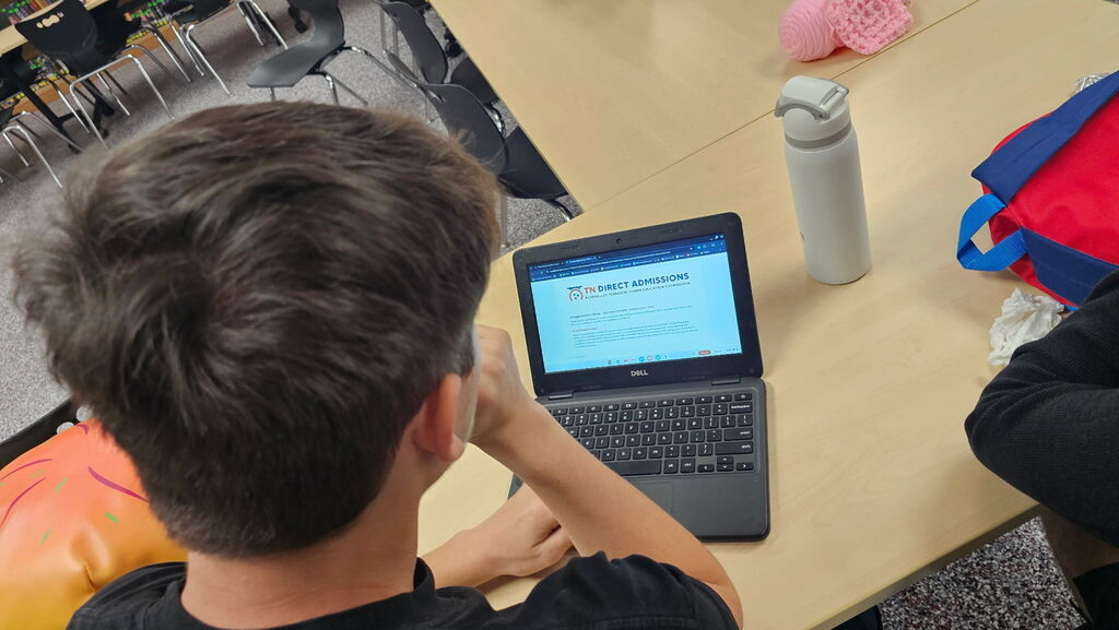 : West Carroll seniors work on laptops around tables in the school library while completing college planning activities and reviewing information online.
