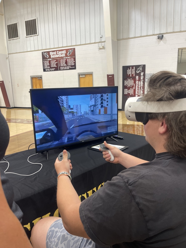 A West Carroll student wears a virtual reality headset and uses handheld controllers while participating in an impaired-driving simulation during the Choices Matter program.