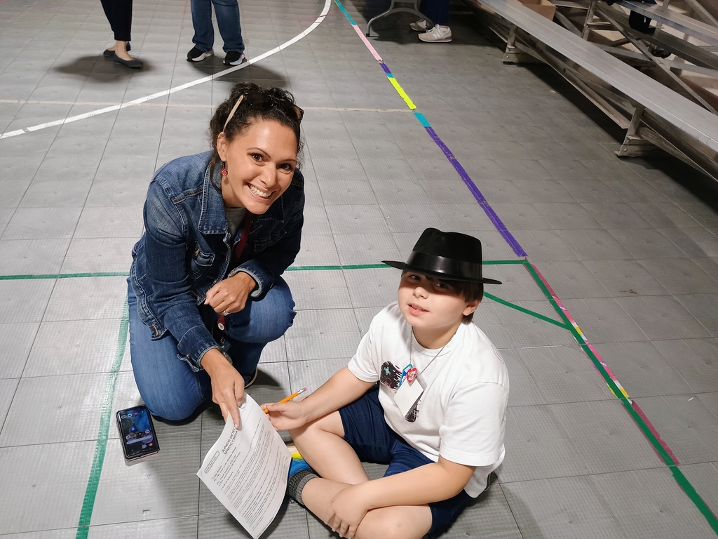 west carroll teacher hleps student as he works on reading mystery