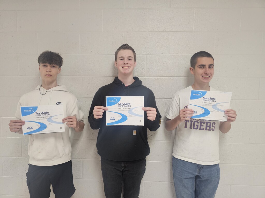 West Carroll Culinary 3 students Grayson Krypciak, Landon Seavers, and Jonah Mims stand together holding their ServSafe certification certificates after passing the ServSafe Manager Certification Exam.