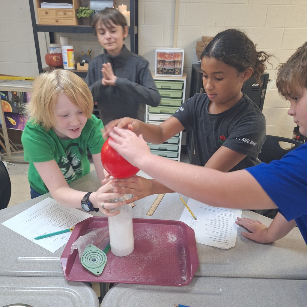 west carroll elementary students performing science experiment about mass conservation