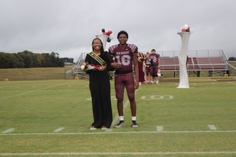 Makayla Bryant: Junior Homecoming representative Makayla Bryant poses on the field with her escort, Demarion Gilbert.