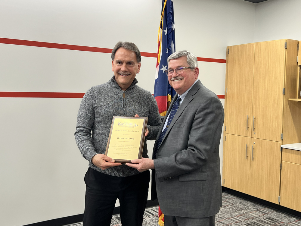 two men holding the Jesse Haines Award plaque between them