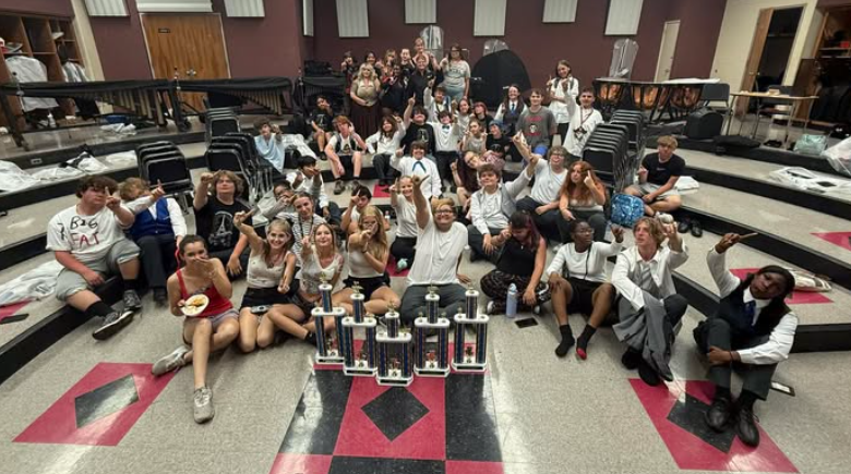 Band students with trophies