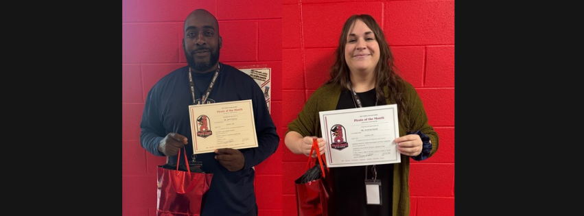 Two people stand against a red wall. Each holds a certificate and a red bag.