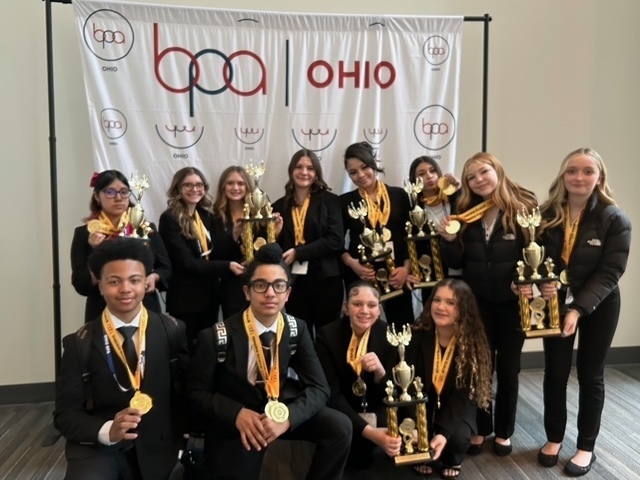 girls and boys wearing medals with five holding trophies