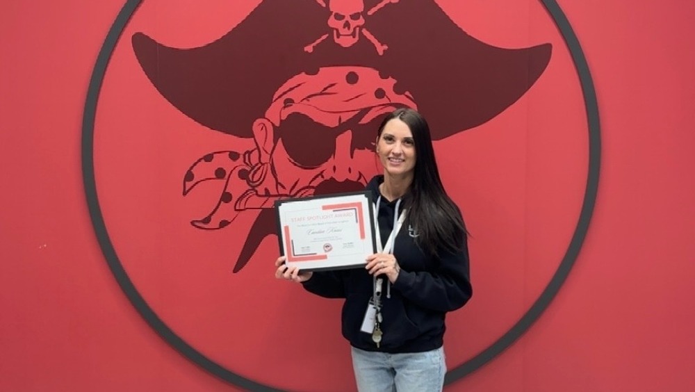 Woman holding staff spotlight certificate