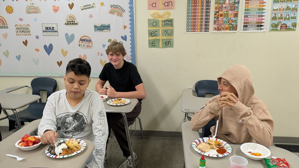 three boys eating at their desks