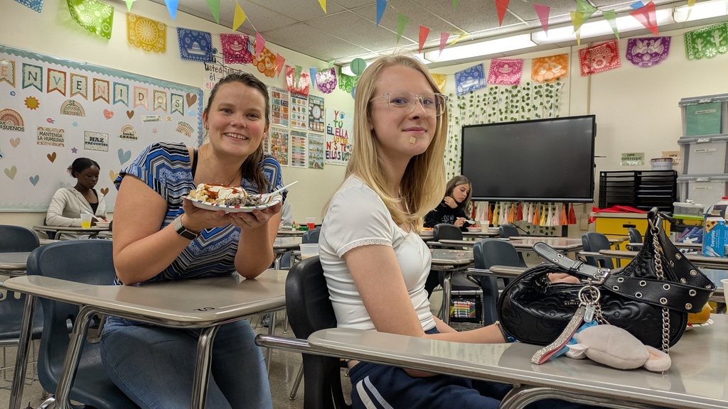 teacher with a plate and a student at the desk