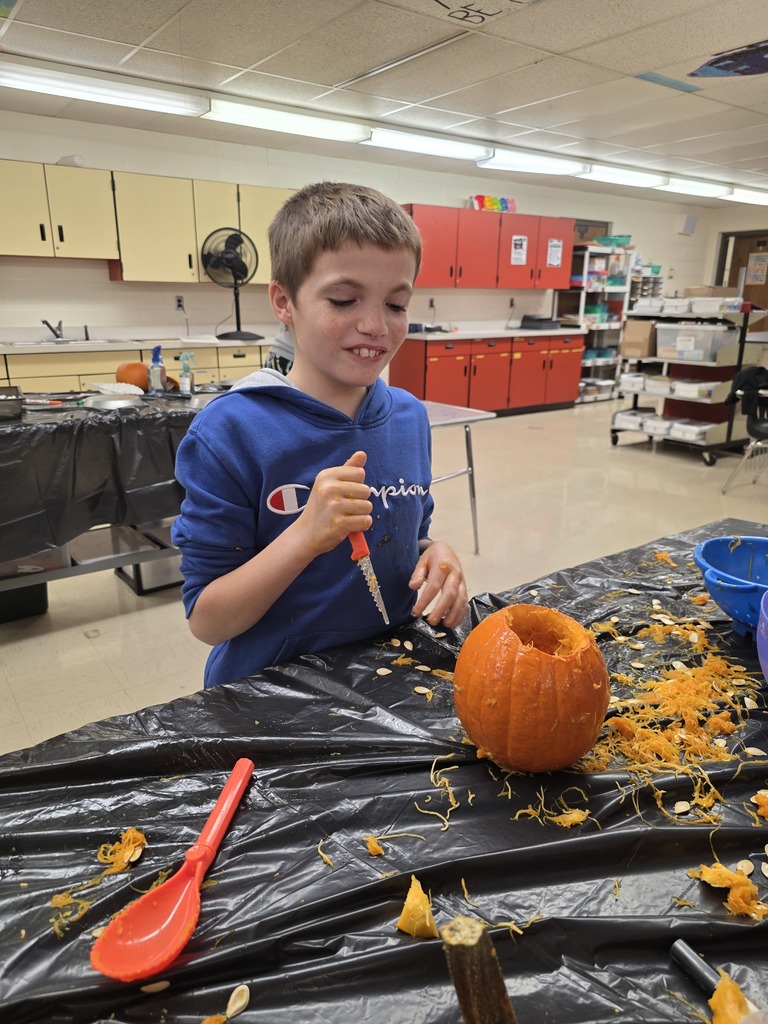 Student carving a pumpkin