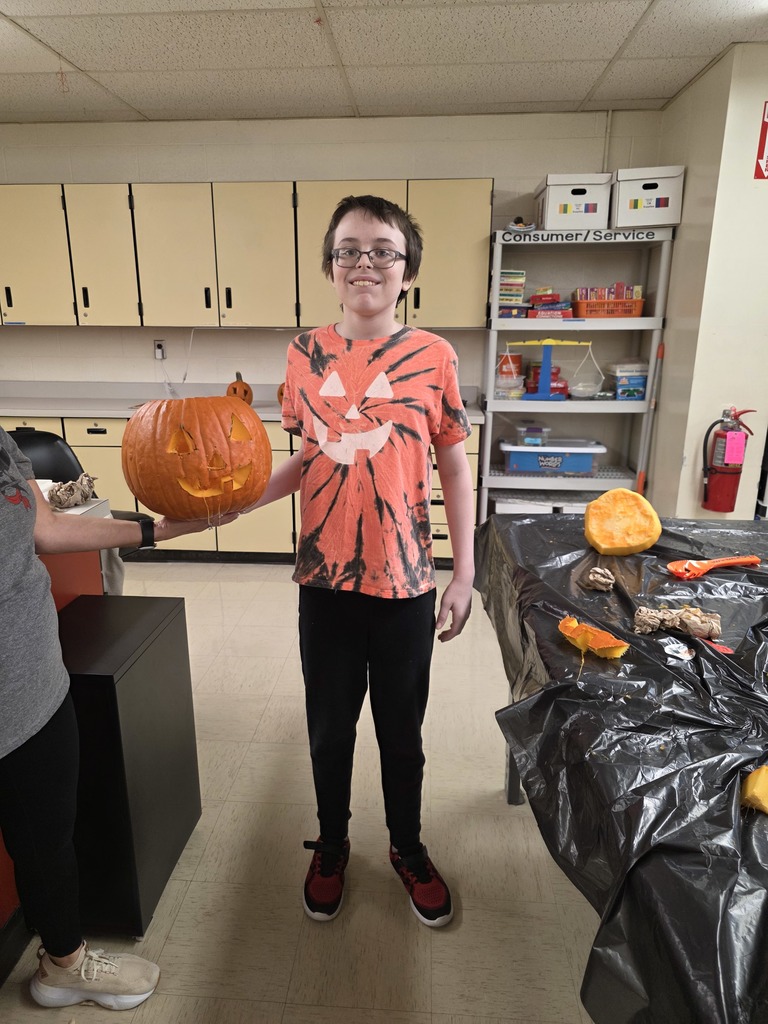 Student carving a pumpkin