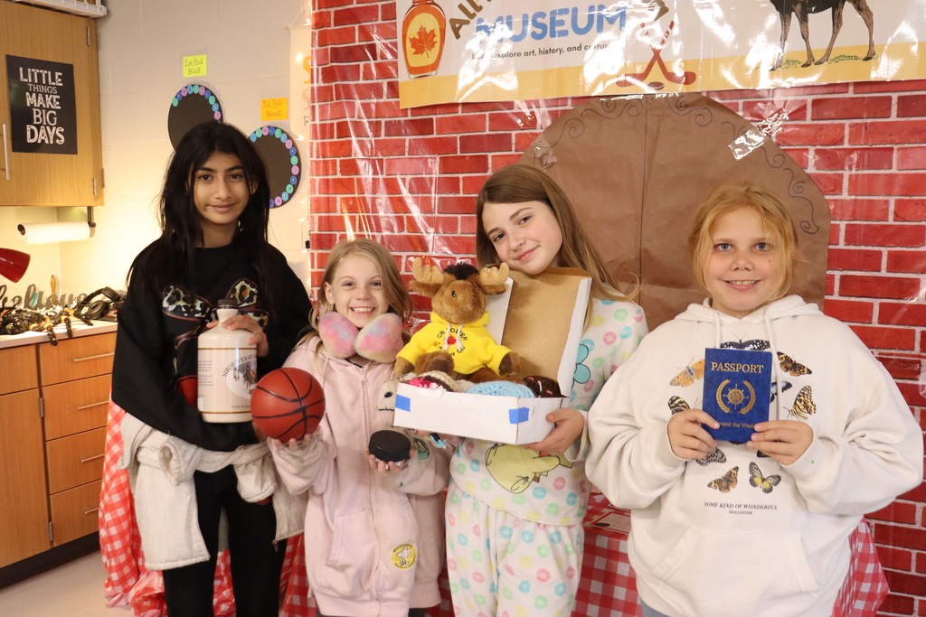 four girls posing with things from Canada