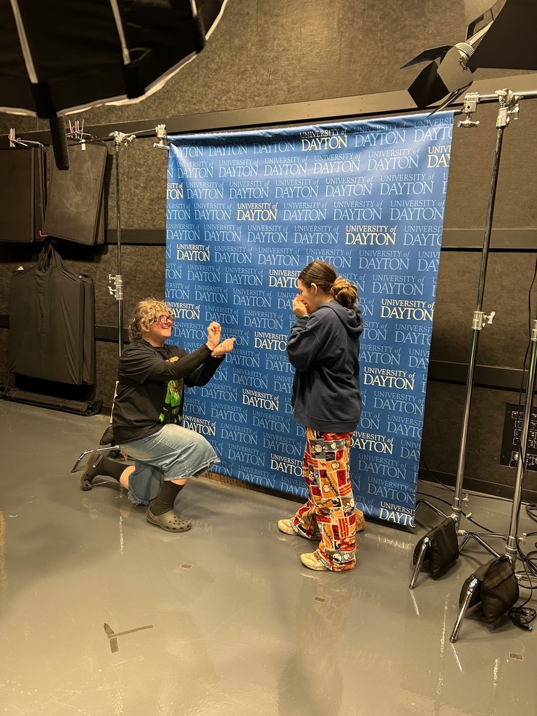 students in front of screen in news studio