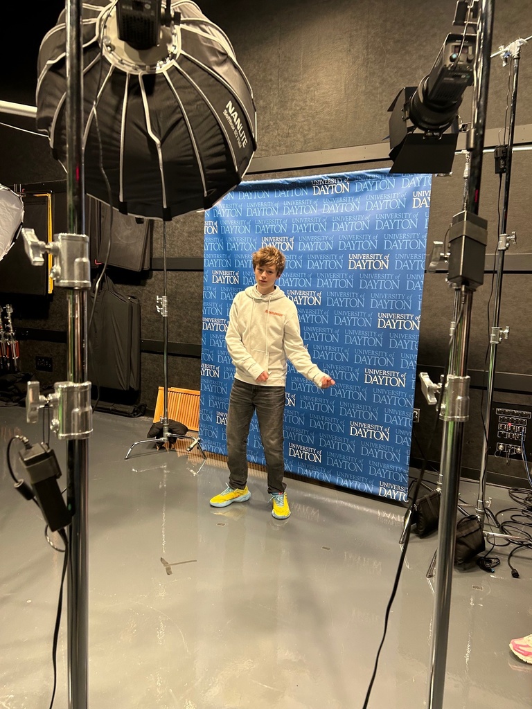 student in front of screen in news studio