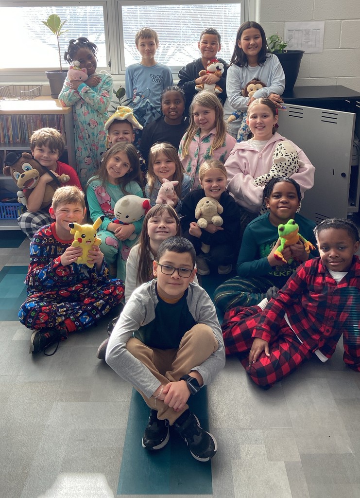 students in pajamas holding stuffed animals