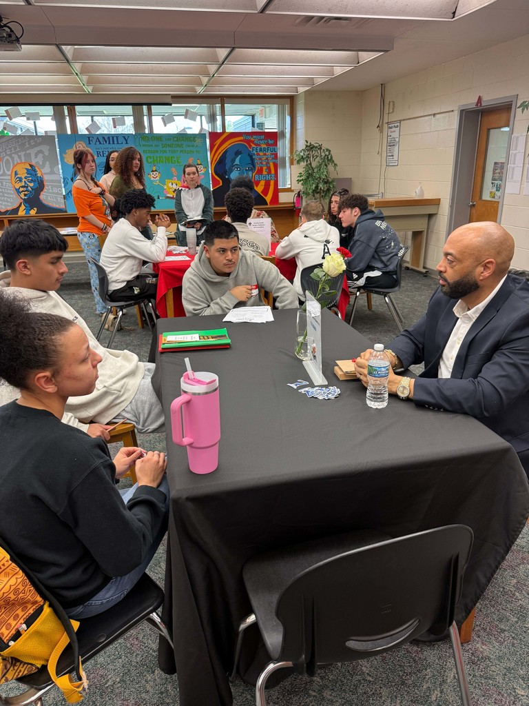 Business partner speaking to three students 