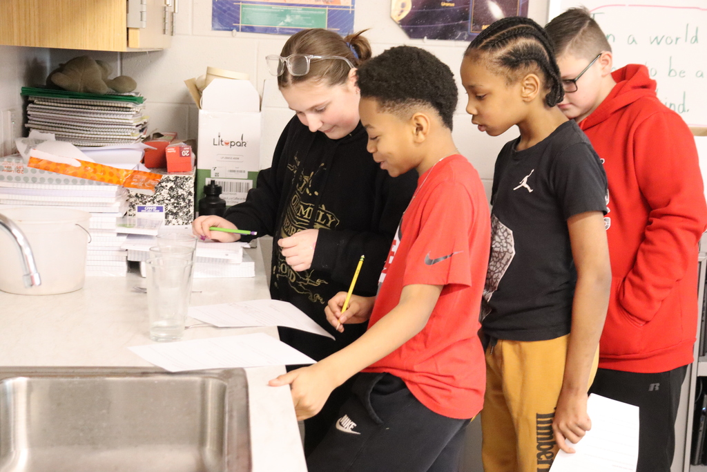 four students listening to sounds in a science experiment