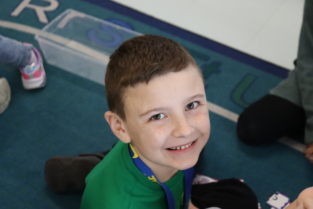 boy wearing a green shirt and smiling