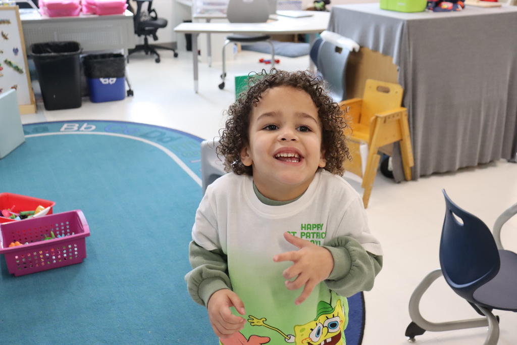 boy with curly hair and green on his shirt