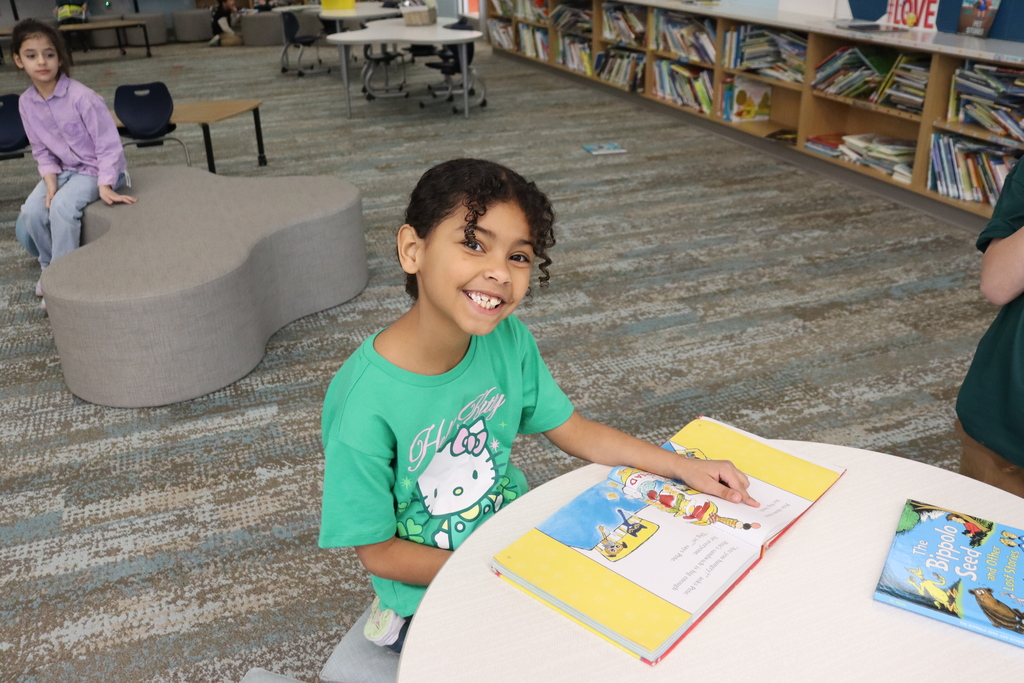 student in a green shirt reading a book