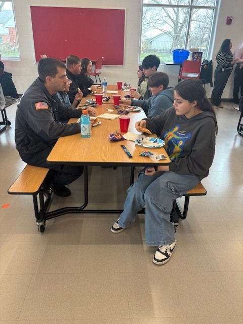 Firefighter eating with students
